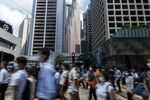 People cross a road at a traffic light during lunch hour in the Central district of Hong Kong, China.
