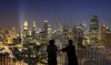 People look out over the central business district skyline in Singapore, on Monday, Aug. 8, 2011. Singapore reduced the top end of its growth forecast for 2011 as a faltering U.S. economy and the European debt crisis heightened the risks to global expansion.