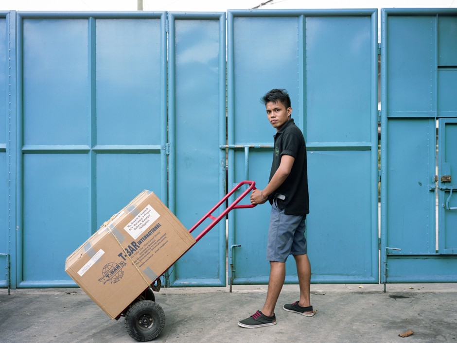 An employee of T-Bar International in Quezon City handles a box sent from a Filipino family in Illinois.