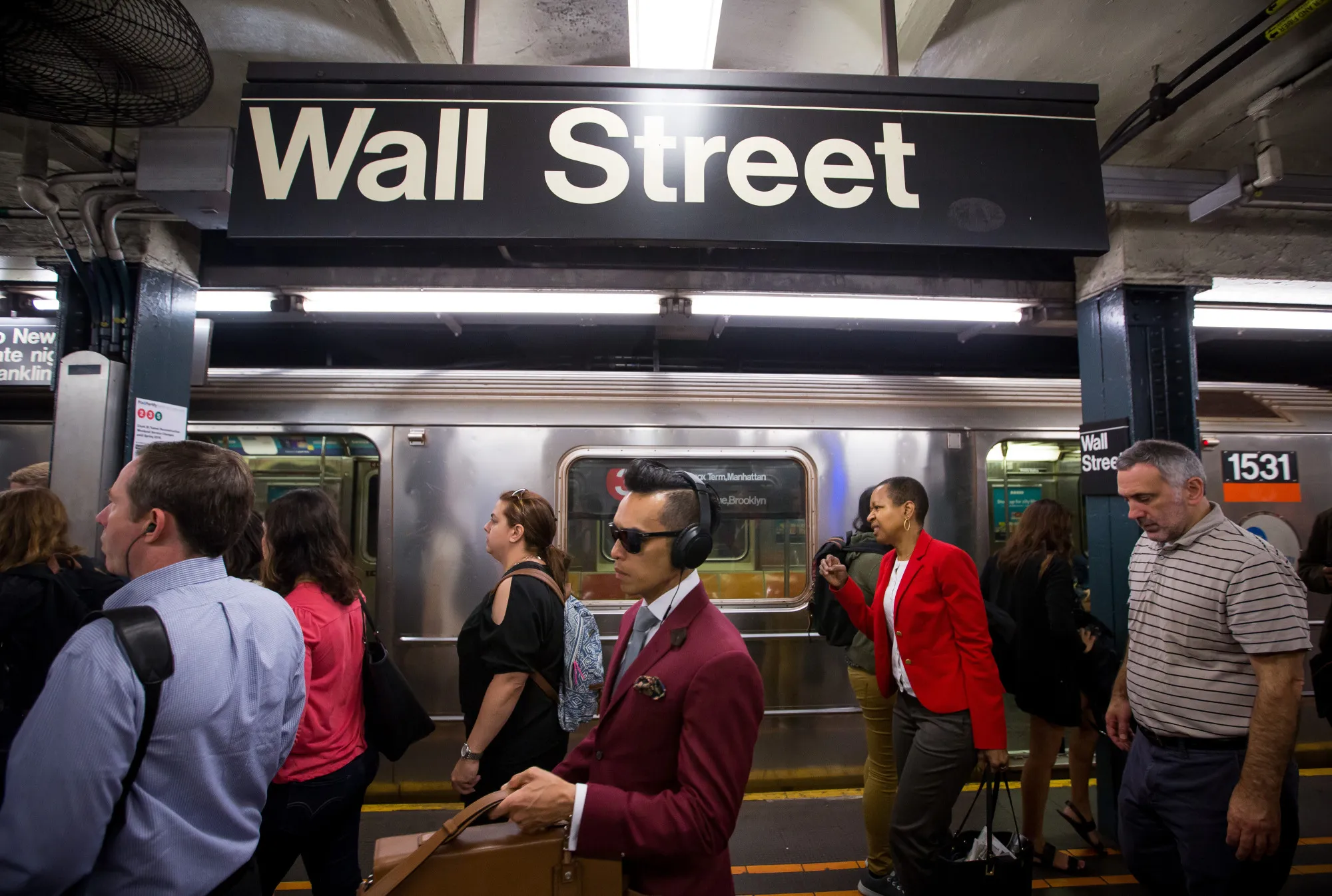 Commuters exit the Wall Street subway station.