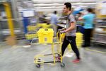 An employee pushes a trolley at the Amazon Inc. warehouse in Hemel Hempstead, U.K.
