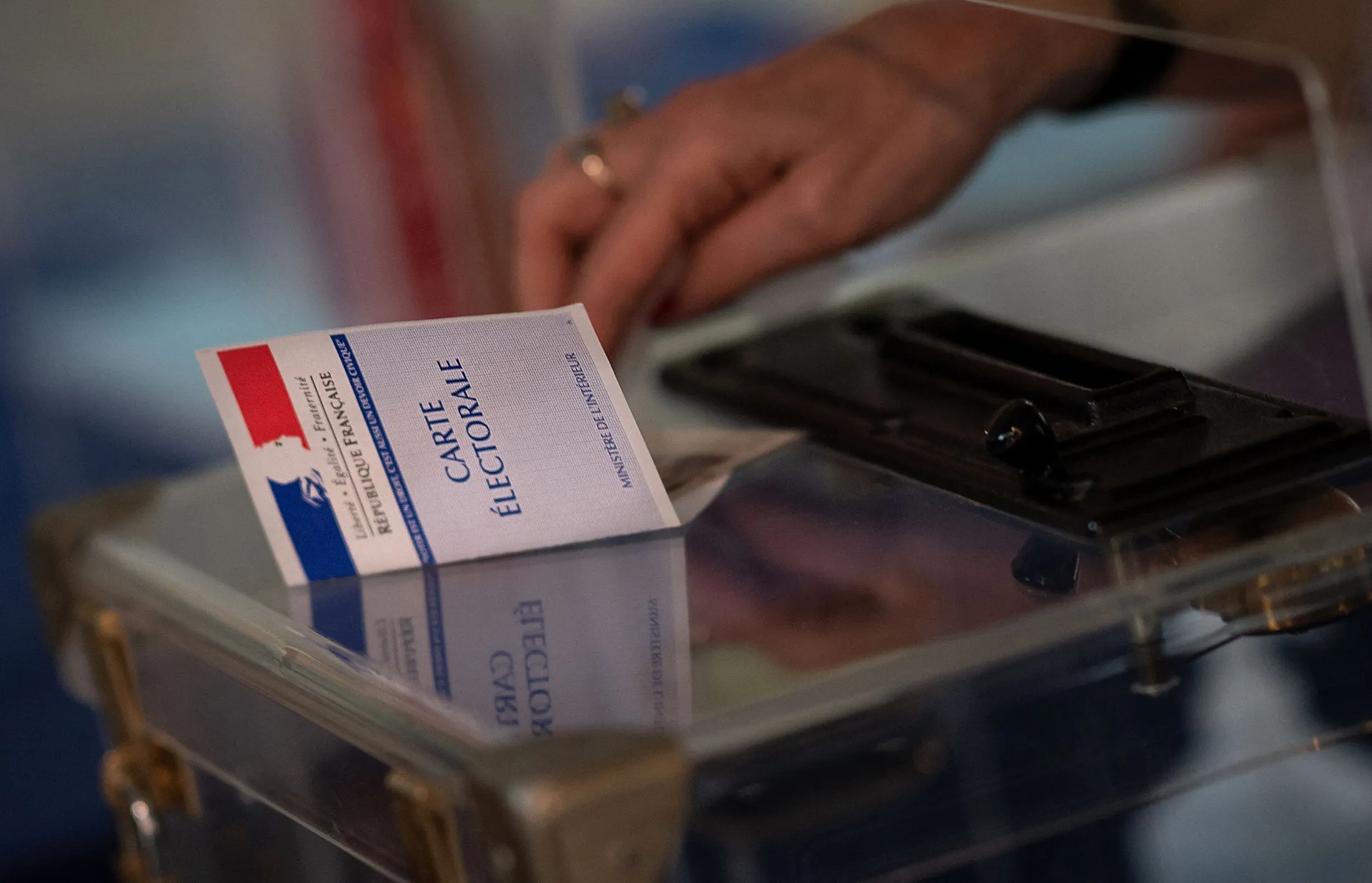 A voter shows an electoral card at a polling station in western France.