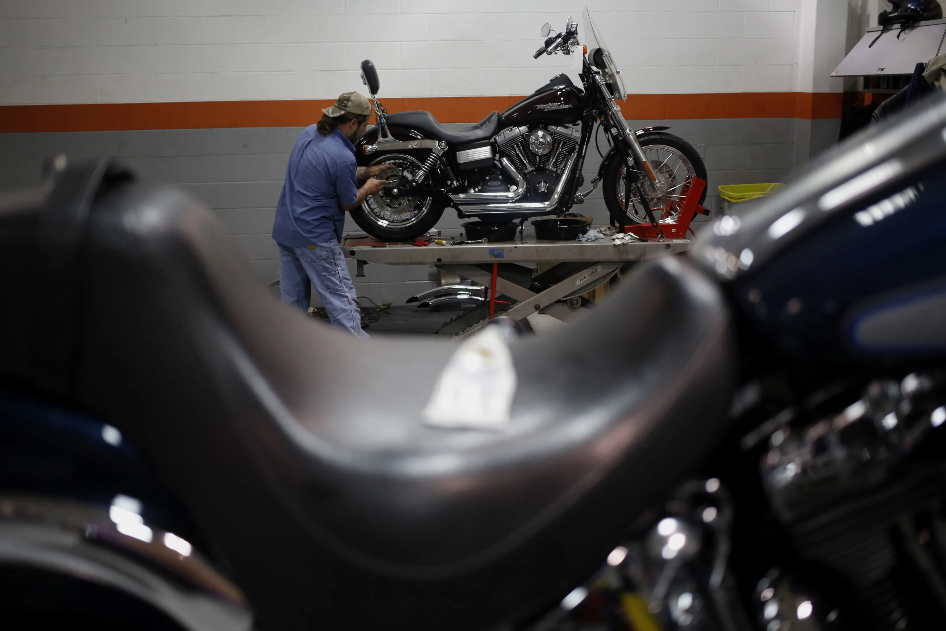 A mechanic works on a Harley-Davidson Inc. motorcycle in the service department of the Worth Harley-Davidson dealership in Kansas City, Missouri.