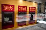 A person wearing a protective mask is reflected in the window of a temporarily closed Wells Fargo & Co. Bank branch in New York on April 10.