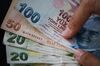 ISTANBUL, TURKEY - AUGUST 13: A woman poses for a photograph with Turkish Lira currency on August 13, 2018 in Istanbul, Turkey.The lira hit another record low overnight forcing Turkey's Central Bank to act to curb the lira's collapse however the action was not enough to subdue investors fears over the countries financial crisis (Photo by Chris McGrath/Getty Images)