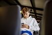 teenager boy is using smartphone at airport waiting zone