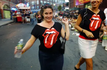 A fan wears a T-shirt emblazoned with the iconic Rolling Stones lips and tongue logo, in use since 1970. The original artwork just sold for $92,500. 