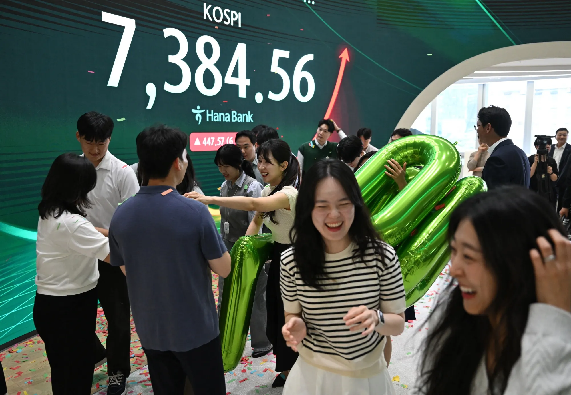 Currency dealers celebrating South Korea's benchmark stock index breaking 7,000 points at the Hana Bank headquarters in Seoul on May 6.