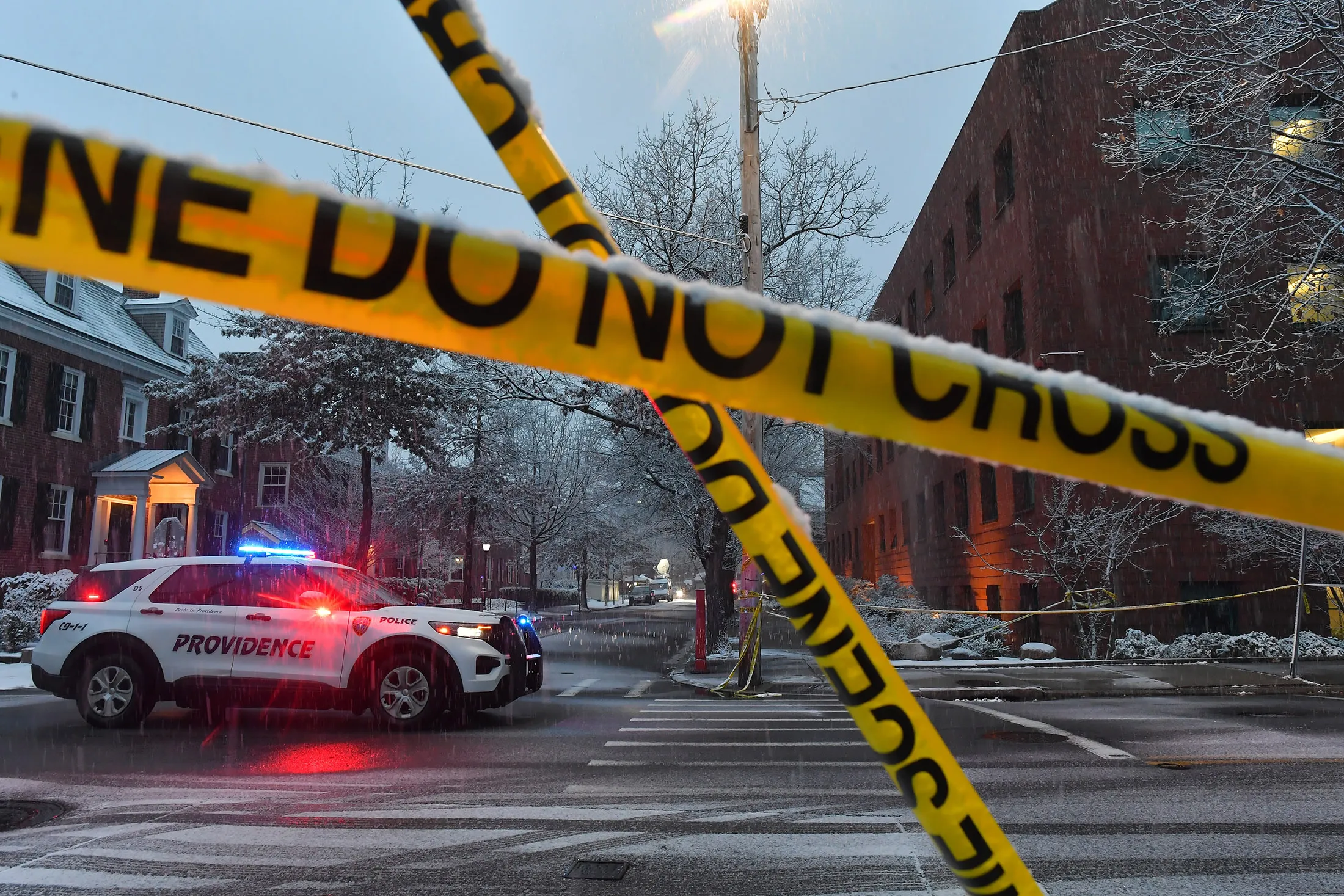 A police vehicle stands guard at an intersection near crime scene tape at Brown University, on Dec. 14.