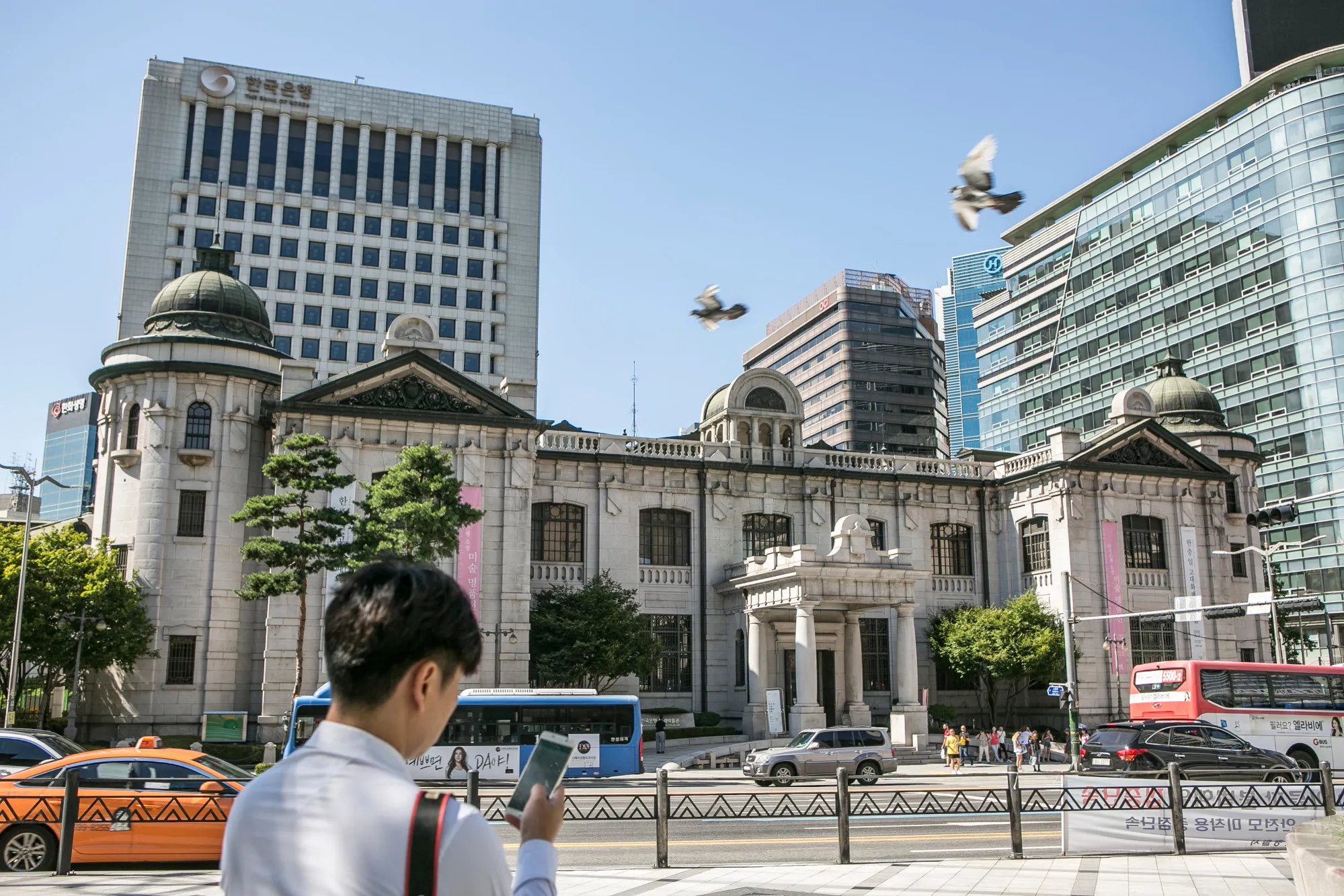 A pedestrian stands outside the Bank of Korea (BOK) museum at the central bank's headquarters in Seoul, South Korea.