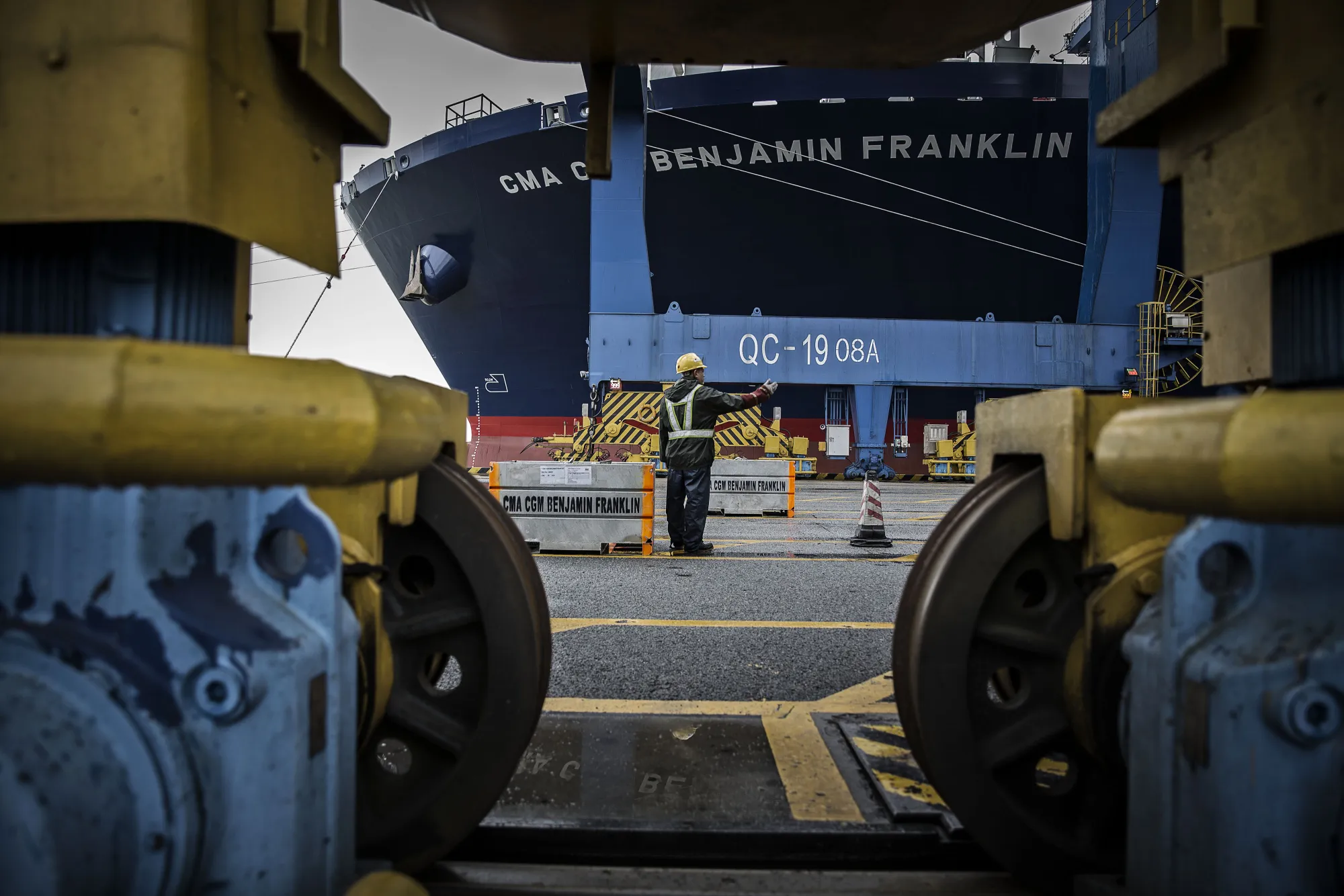 A dock worker directs the loading of shipping containers&nbsp;at the Guangzhou Nansha Container Port in Guangzhou, China.