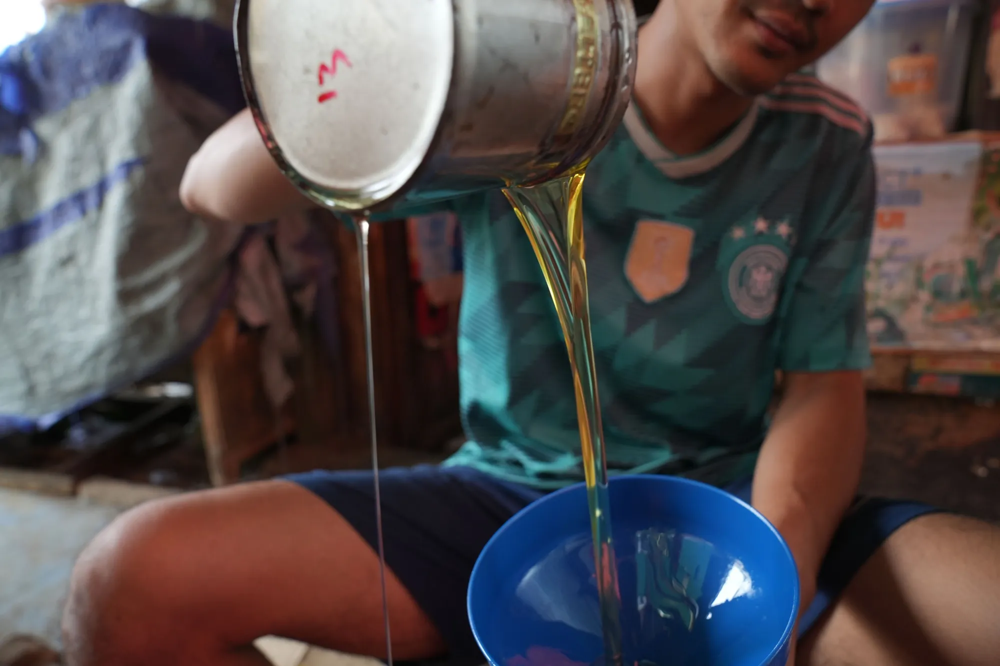 A shopkeeper packages cooking oil at Kambing Market in Jakarta, Indonesia&nbsp;on&nbsp;April&nbsp;26.