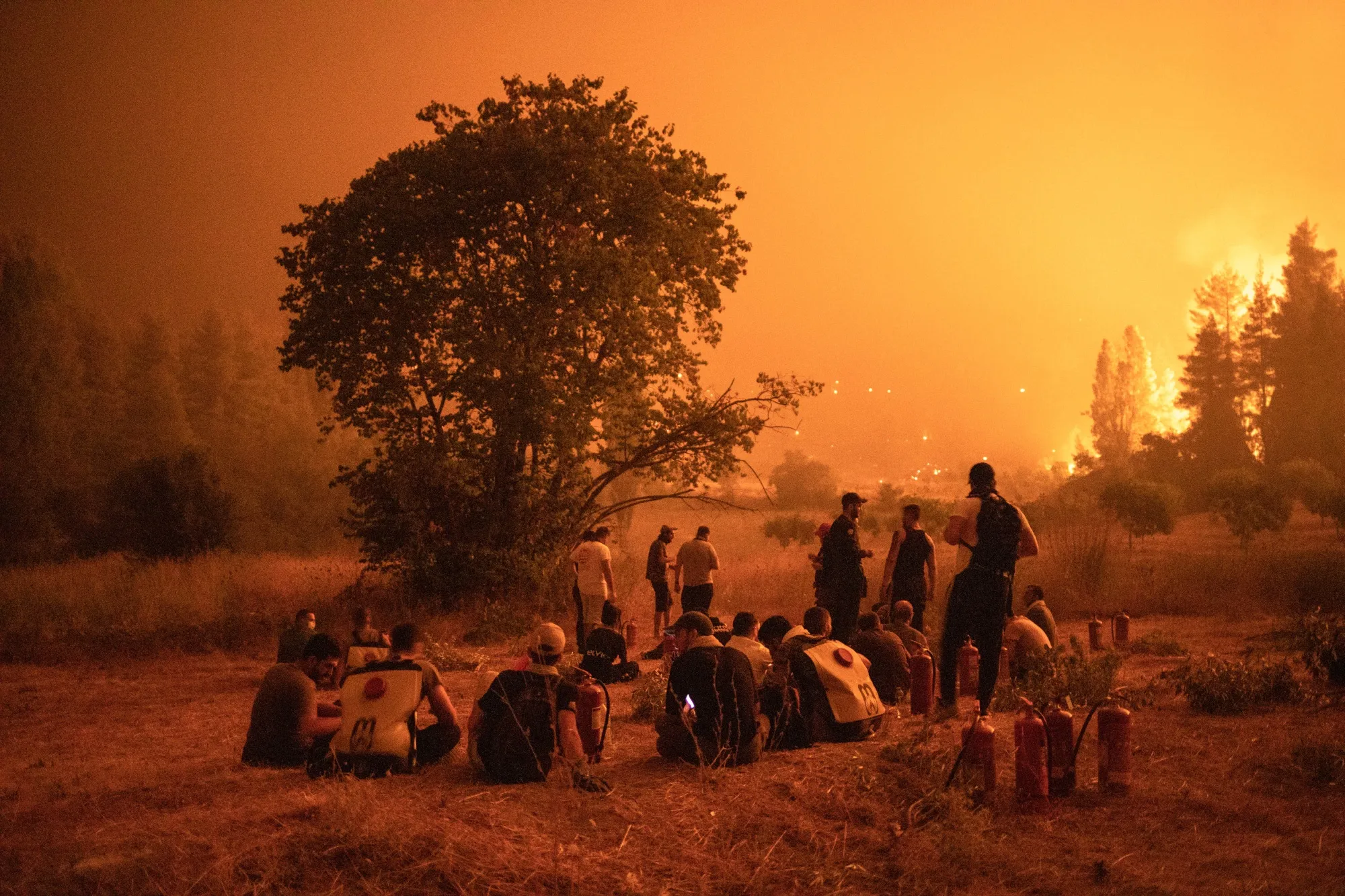 Residents gather to watch over the wildfire and&nbsp;support firefighters outside the village of Kamatriades, on Evia island, Greece, Aug. 9, 2021.&nbsp;