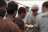 Richard Gere helps serving meals to migrants aboard the Open Arms Spanish humanitarian boat on Aug. 9.