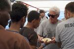 Richard Gere helps serving meals to migrants aboard the Open Arms Spanish humanitarian boat on Aug. 9.