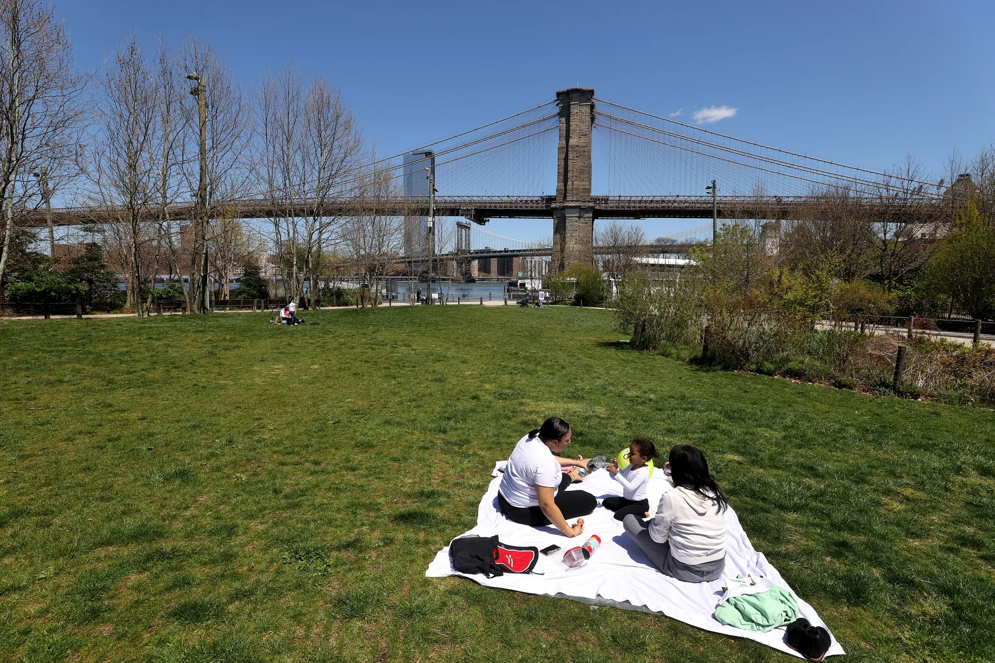 A family picnics on the grass at Brooklyn Bridge Park in April in New York City.&nbsp;