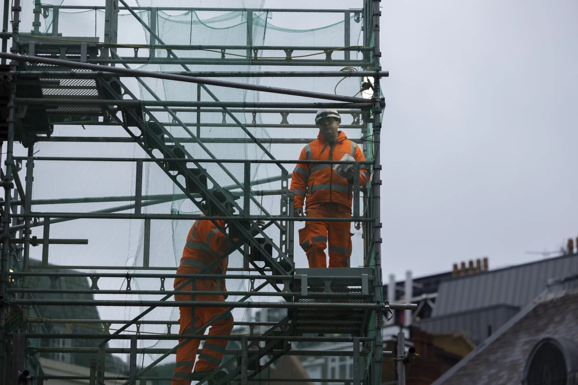 Construction workers climb scaffolding in London, on Jan. 16.