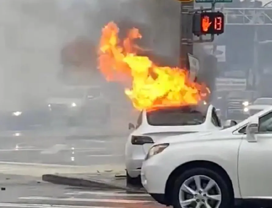 The vehicle on fire following the crash.