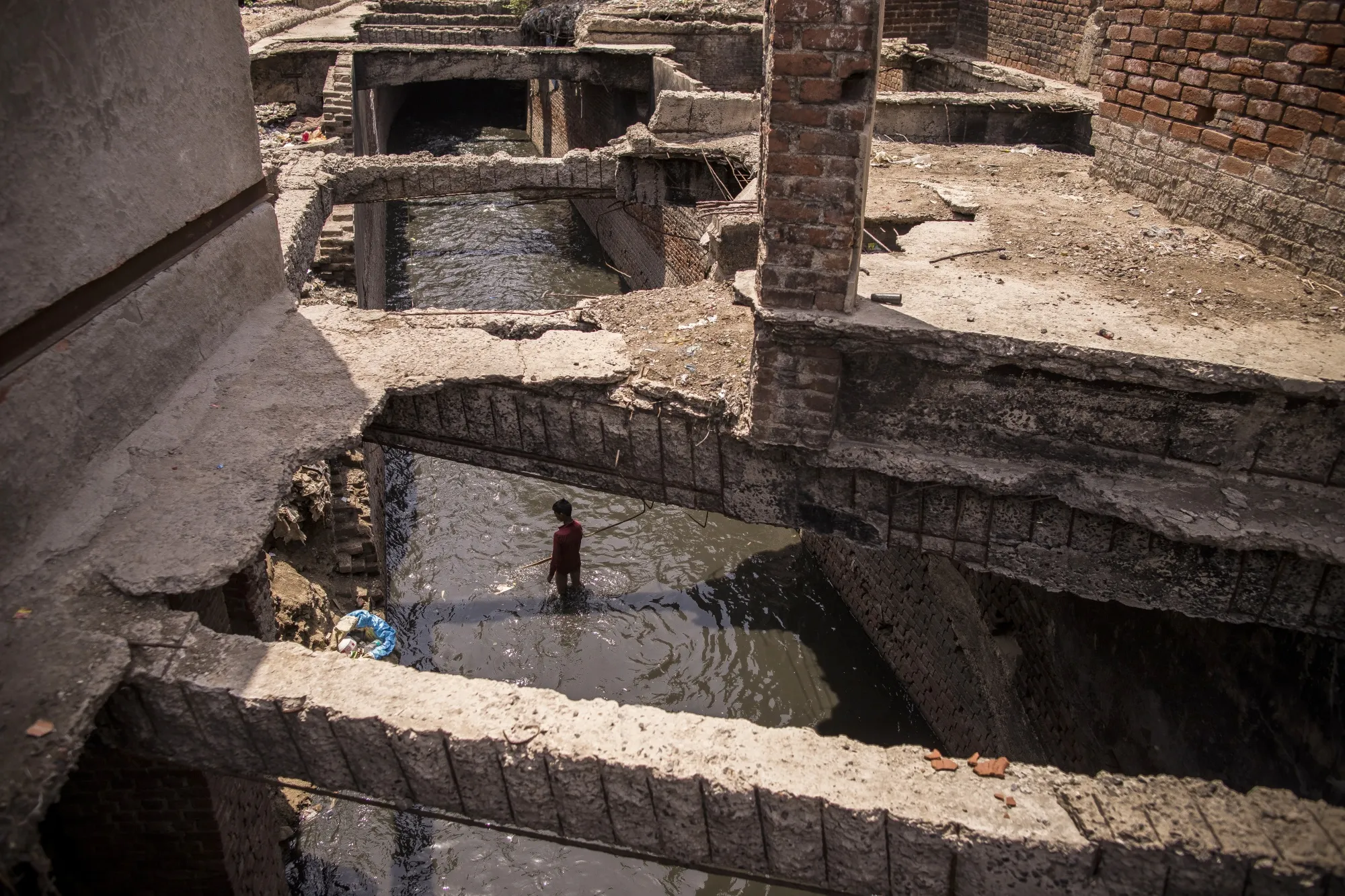 A man scavenges in a stream during lockdown restrictions in Agra on June 6.&nbsp;The pandemic has erased years of economic progress in India with millions now facing grim job prospects and heavy debt loads.