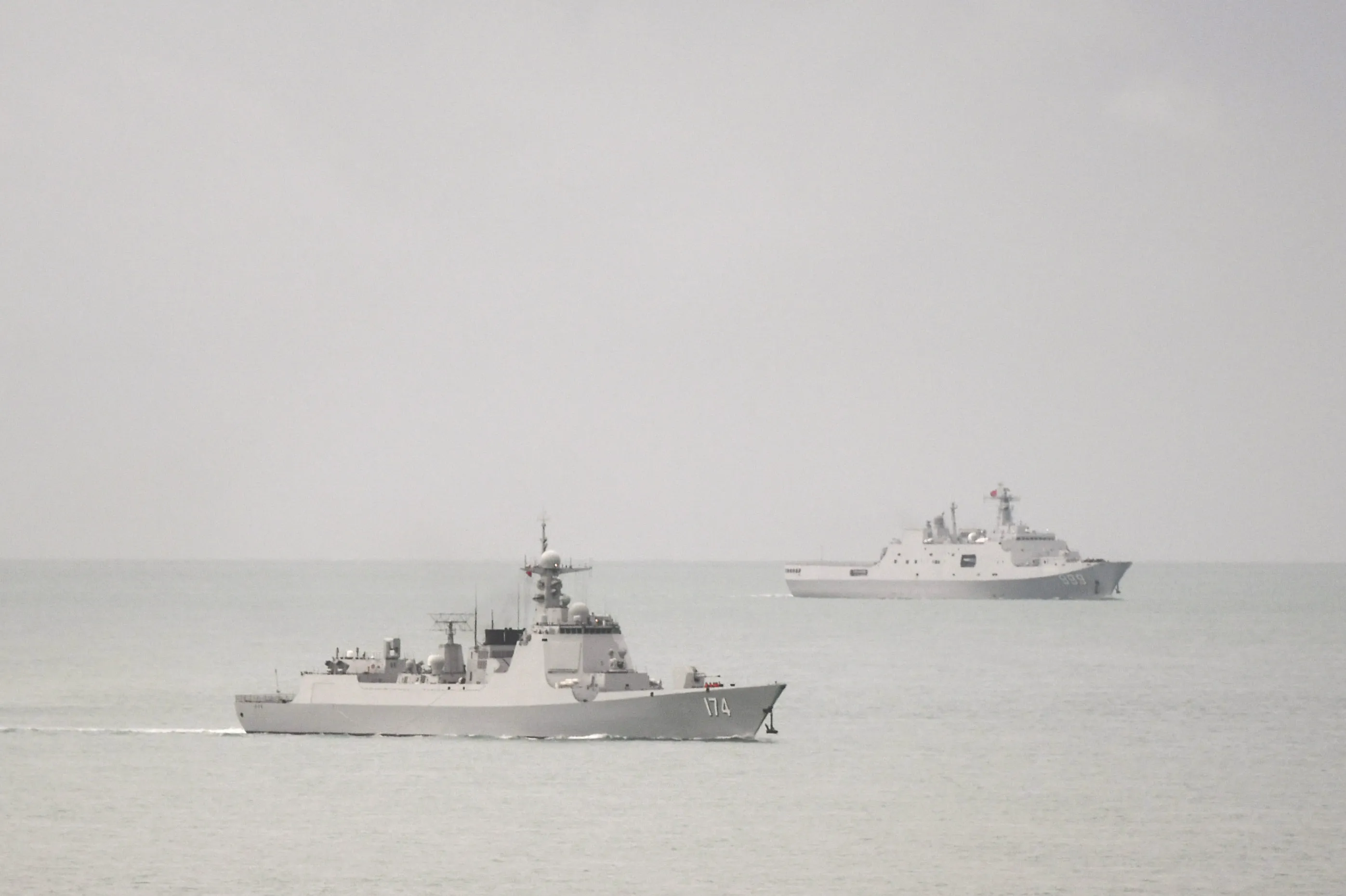 A People’s Liberation Army Navy Luyang-class guided missile destroyer, left, and a Yuzhao-class amphibious transport dock vessel leave the Torres Strait and enter the Coral Sea on Feb. 18.