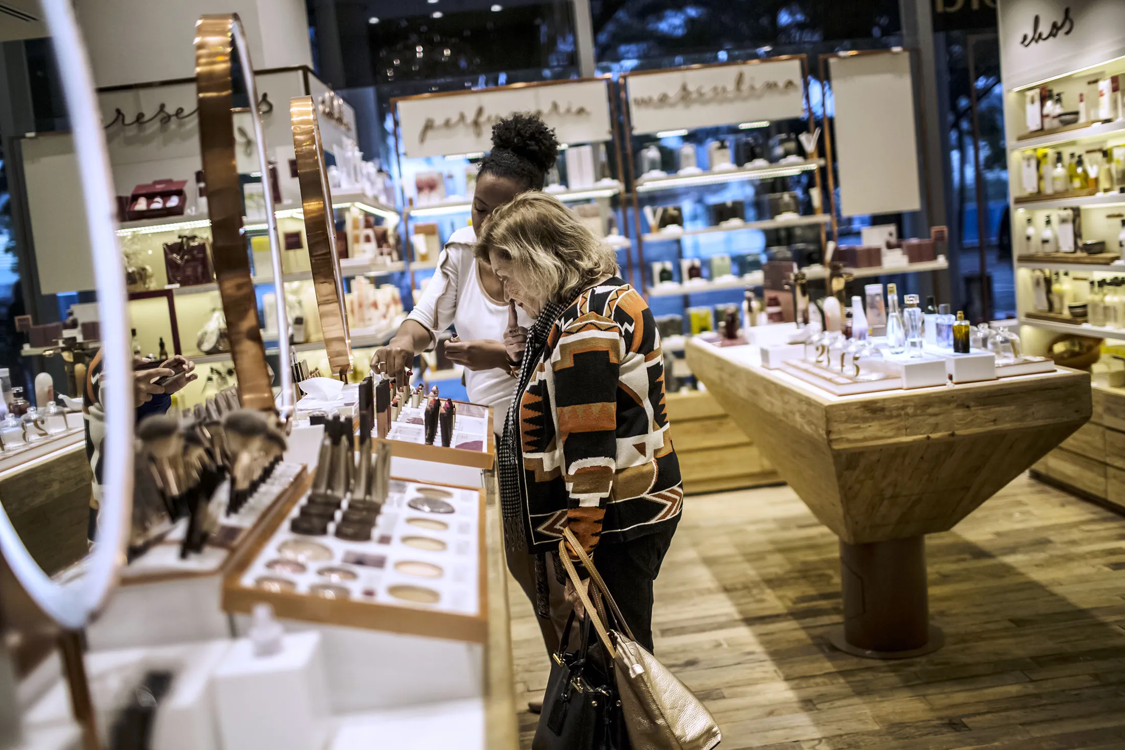 An employee assists a customer viewing makeup on display at a Natura store inside the Santos Dumont Airport (SDU) in Rio de Janeiro, Brazil.&nbsp;