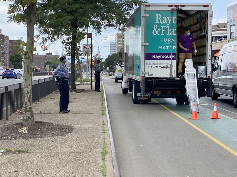 A driver getting hit with a traffic ticket for blocking a bike lane in Queens, New York.