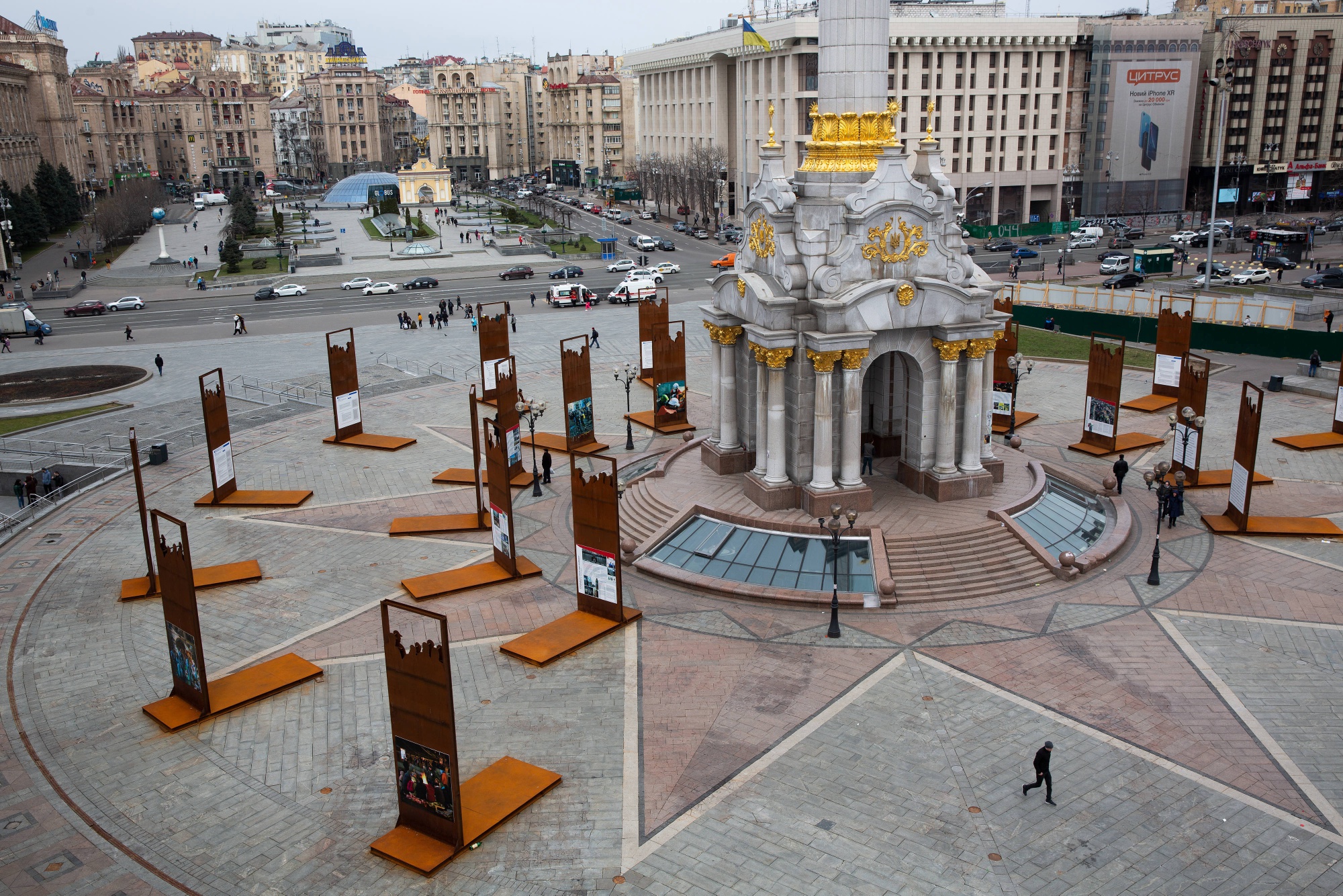 Pedestrians walk past the independence monument on Independence Square, also known as Maidan, in Kiev, Ukraine.