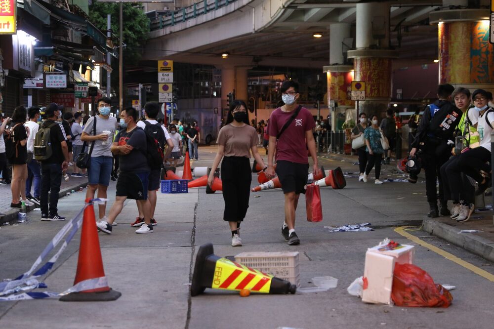 People move around the debris of roadblocks set by protesters during a protest against a planned national security law in the Wan Chai district in Hong Kong, China, on Sunday, May 24, 2020. 