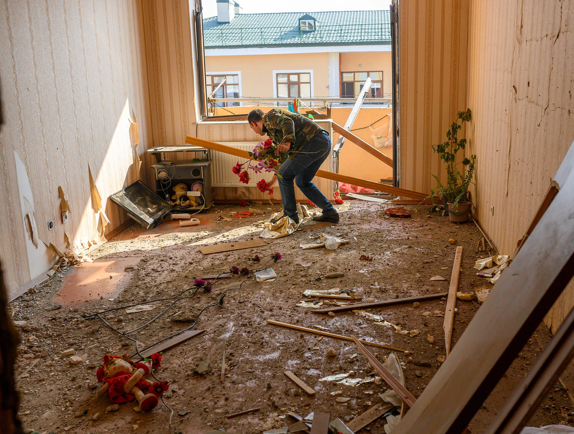 A man collects plastic flowers form his damaged home in Terter,&nbsp;&nbsp;Azerbaijan on Oct.&nbsp;18.