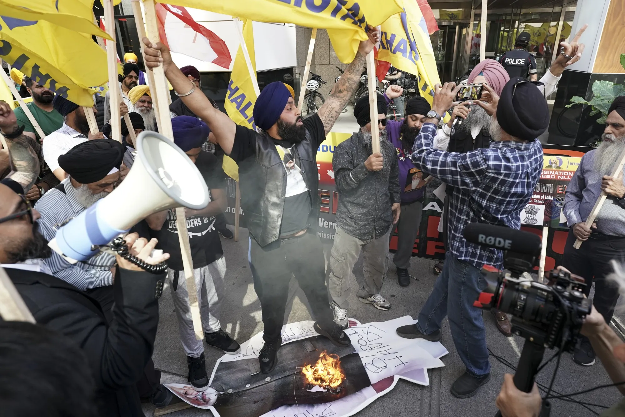 Protestors burn a picture of Prime Minster Narendra Modi outside the Indian consulate in Toronto.