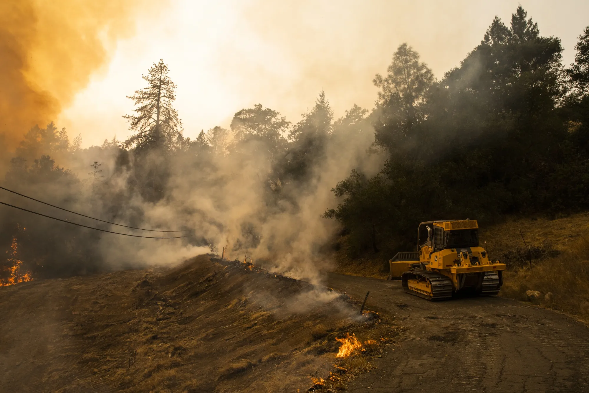 Firefighters monitor a controlled burn from a bulldozer during the Glass Fire near Calistoga, California, on Oct. 2.