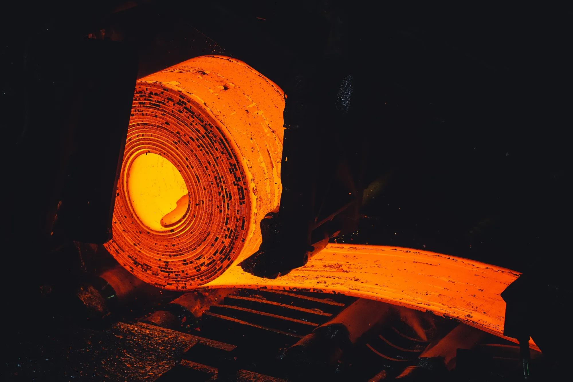 A heated and stretched steel slab is coiled.