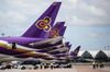 Employees stand next to Thai Airways International Pcl aircraft parked at Suvarnabhumi Airport in Bangkok, Thailand, on Wednesday, Aug. 31, 2016. After a five-year austerity drive, Thai Airways is ready to expand again. The airline, which last ordered planes in 2011, is drawing up a 10-year plan through 2027 that will include aircraft purchases to help boost passenger growth.