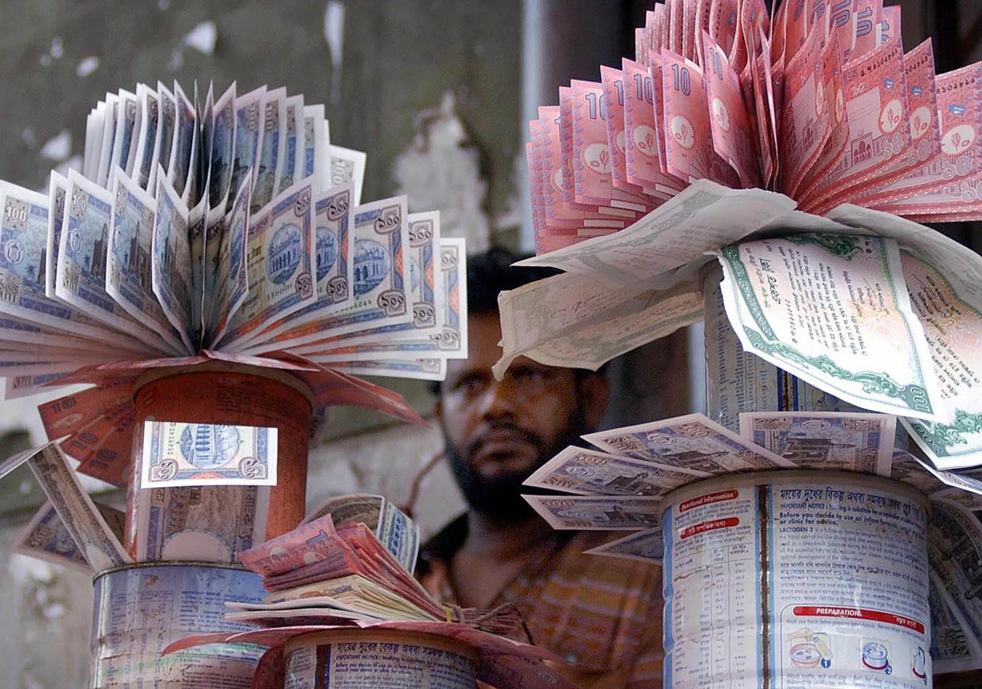 A Bangladeshi money dealer displays clean bundles of Taka, the country's currency, in his shop, in Dhaka, 07August 2003. Many of the notes which are in circulation, except for the 500 takas, are soiled or torn, Bangladesh has currency notes in denominations of one, two, five, 10, 20, 50, 100 and 500 takas, with a taka being worth about 1.7 U.S. cents. AFP PHOTO/Shawkat KHAN (Photo credit should read SHAWKAT KHAN/AFP/Getty Images)
