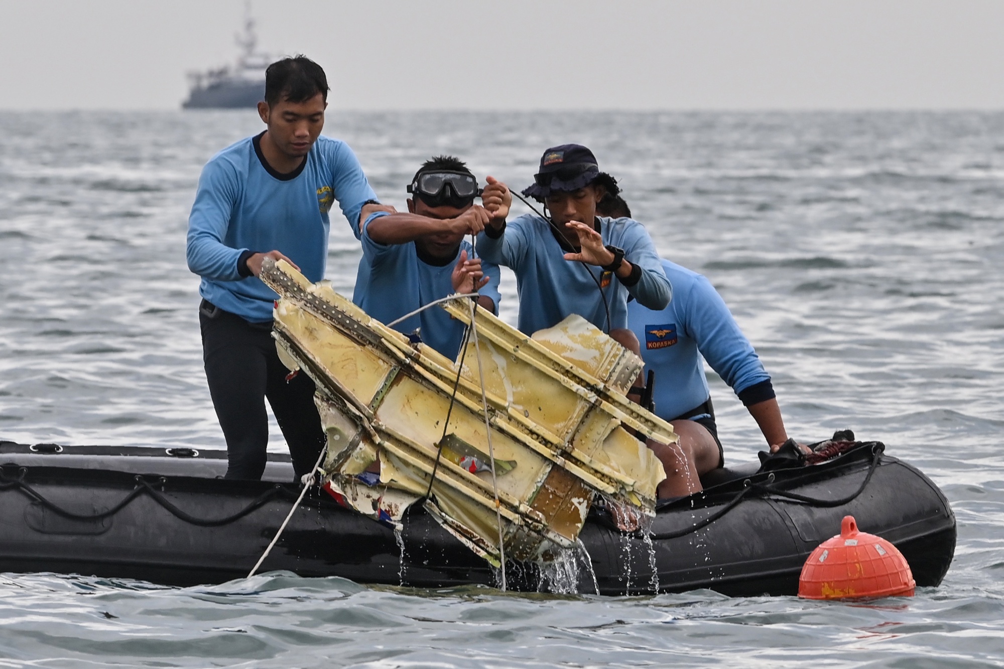 Navy divers hold wreckage from Sriwijaya Air flight SJY182 at sea near Lancang island on Jan. 10.