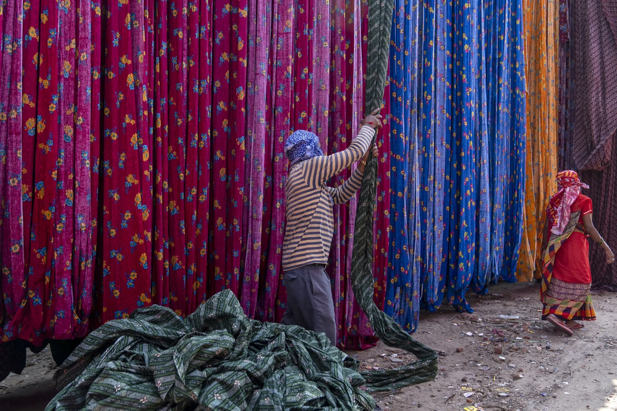 A worker handles&nbsp;textiles on the outskirts of Ahmedabad, India.