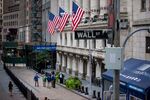 Traders stand in front of the New York Stock Exchange (NYSE) in New York, U.S., on Monday, Aug. 21, 2017. U.S.