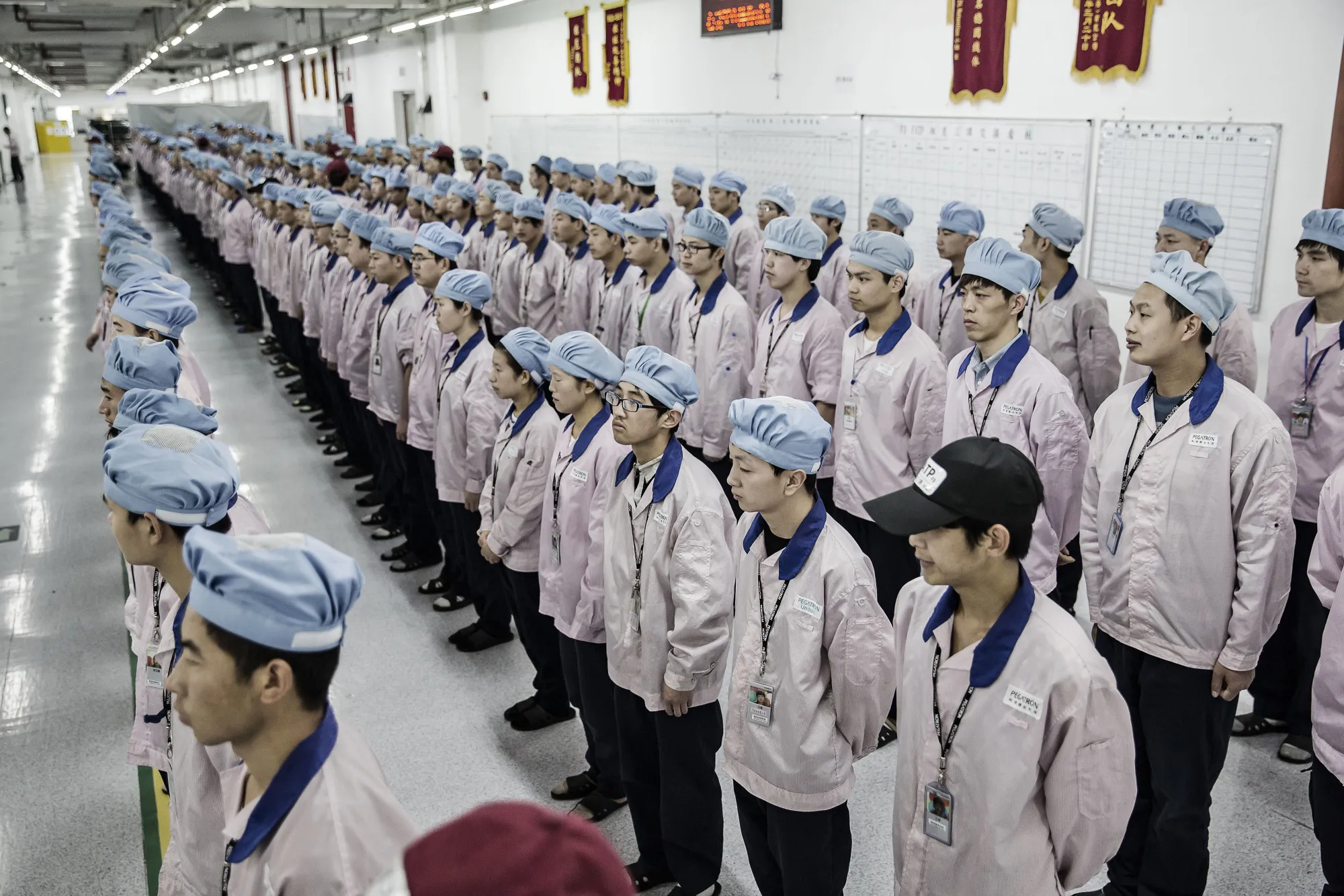 Employees line up for roll call at a Pegatron Corp. factory in Shanghai.