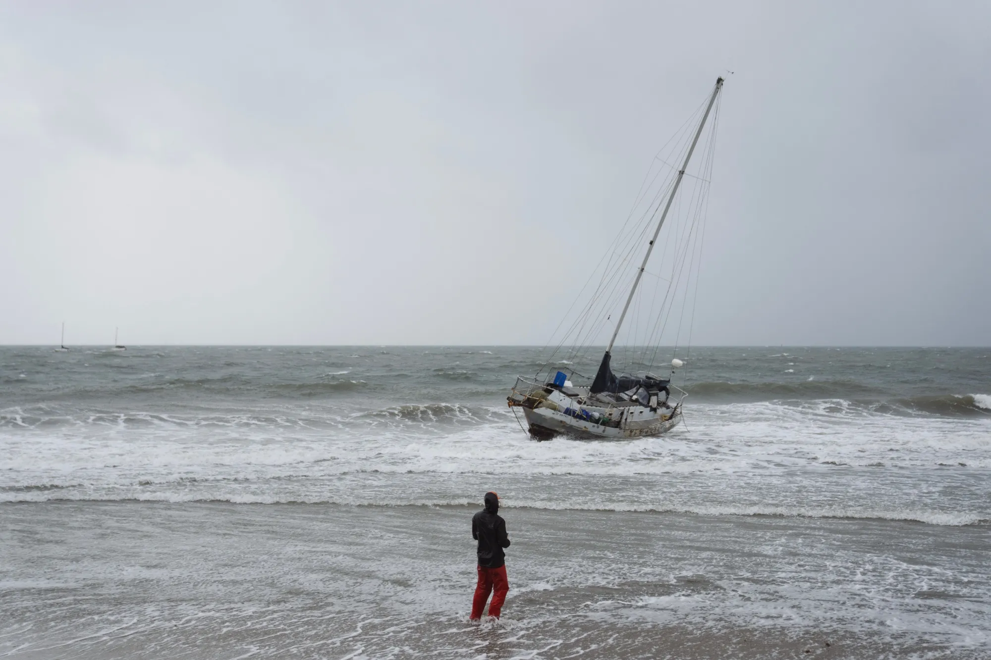 A resident watches as a boat runs aground during a storm in Santa Barbara, California on Sunday.