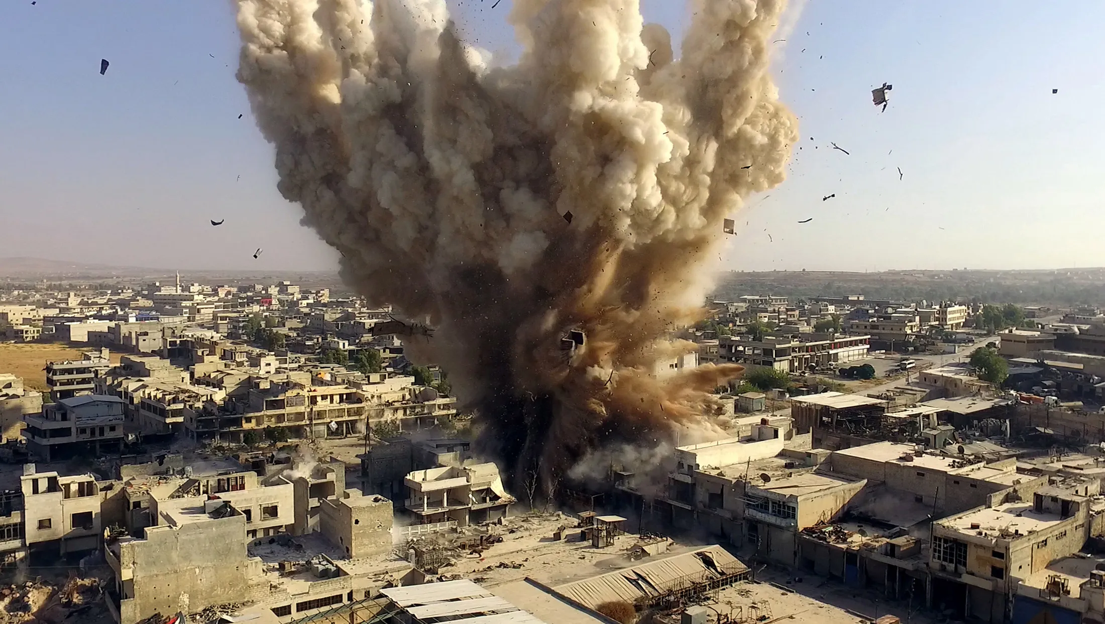 Smoke and rubble rise after Syrian oppositions blow up a tunnel under Syrian Regime forces' headquarters in Aleppo's Ramuse region, Syria on Aug. 3, 2016.
