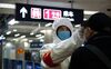 A health worker checks the temperature of a man entering the subway in Beijing on Jan. 26, 2020.