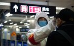 A health worker checks the temperature of a man entering the subway in Beijing on Jan. 26, 2020.