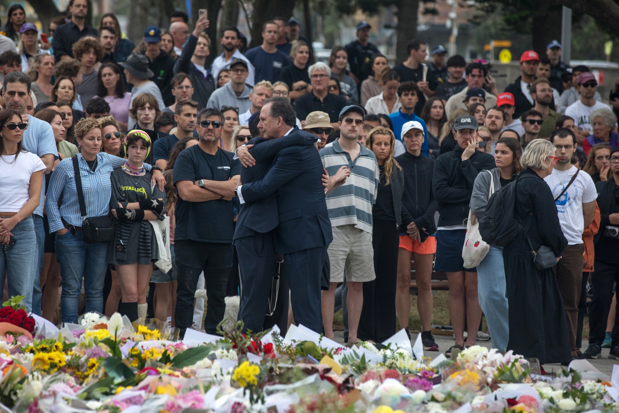 Mourners gather near the site of the mass shooting at Bondi Beach in Sydney, Australia, on Monday, Dec. 15, 2025. Australia will consider toughening gun laws after a father and his son killed 15 people in the nation's deadliest terror attack, opening fire on members of the Jewish community who were celebrating the start of Hanukkah at Sydney's iconic Bondi Beach on Sunday evening. Photographer: Brent Lewin/Bloomberg