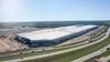 Aerial view of a car factory against the backdrop of a clear blue sky and rural Texas.