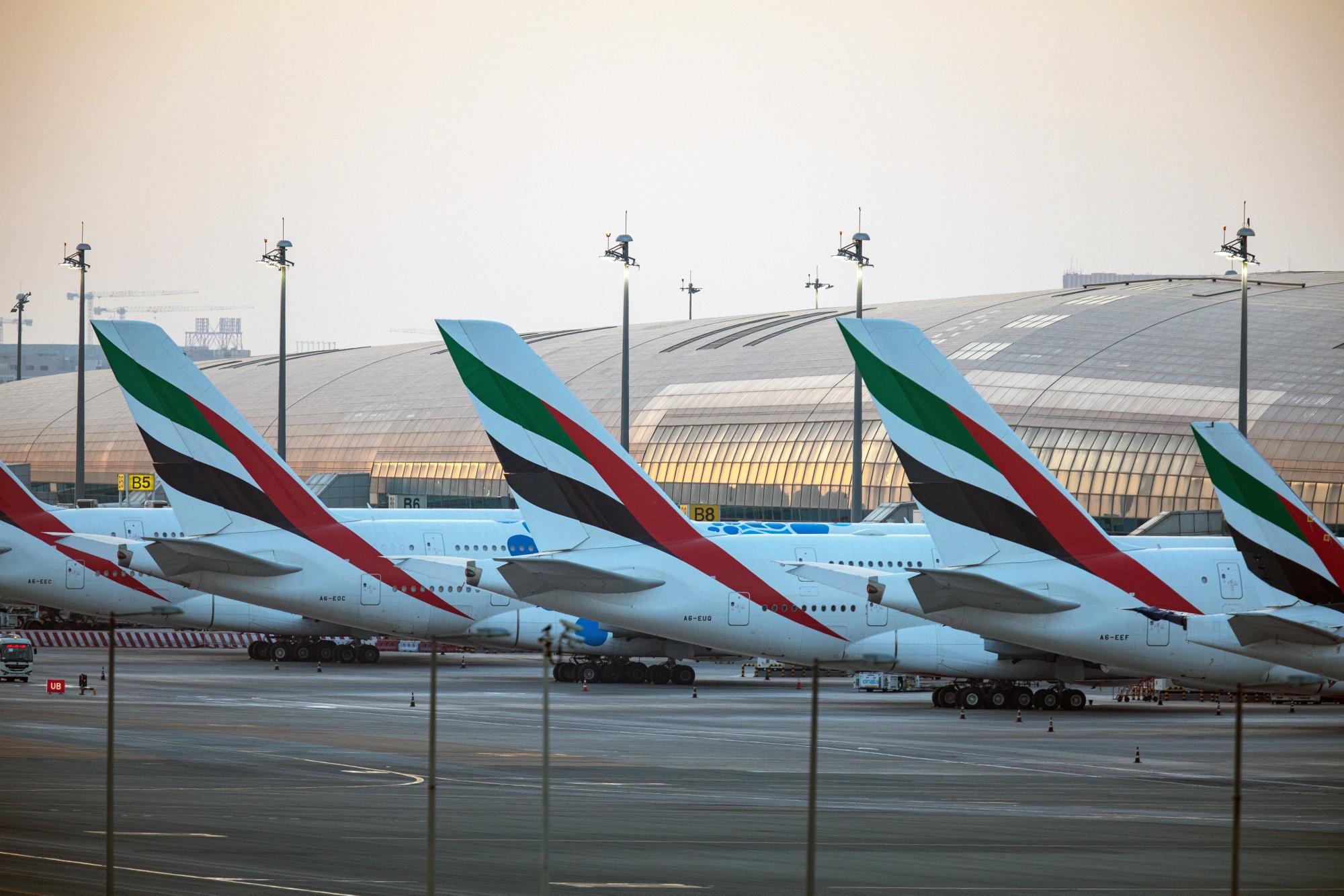 A line of passenger aircraft, operated by Emirates, stand beside the terminal building at Dubai International Airport in Dubai, on May 18.