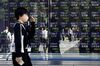 Pedestrians reflected in an electronic stock board outside a securities firm in Tokyo, Japan, on Thursday, Oct. 29, 2020.