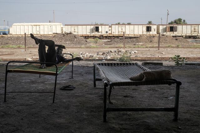 A man resting near a rail yard. 