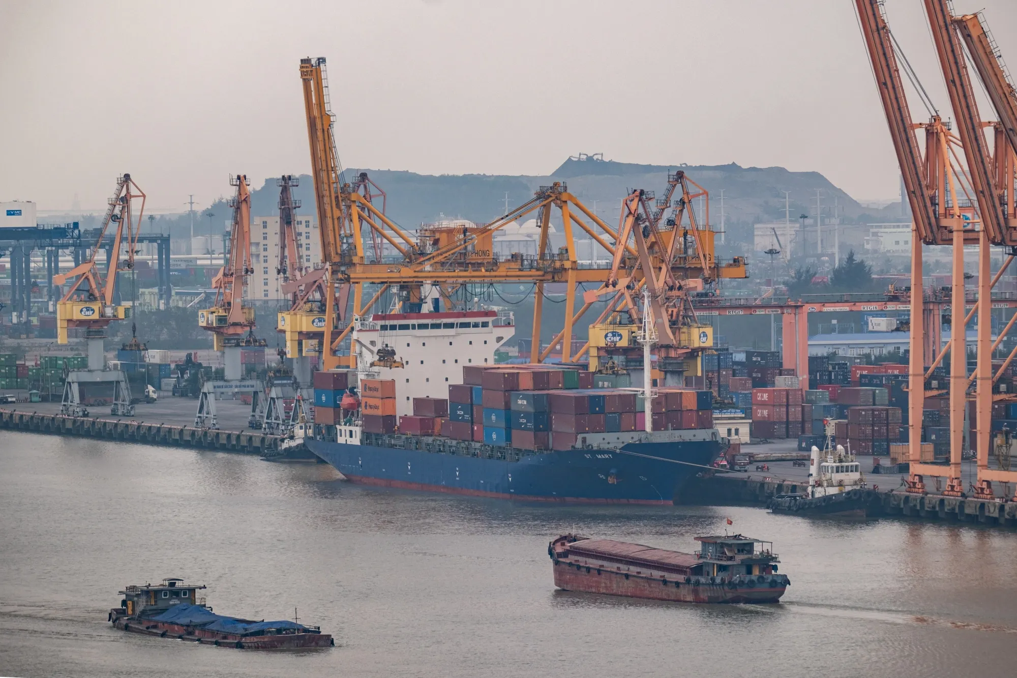 Barges sail past the Tan Vu port in Hai Phong, Vietnam.