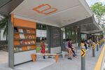 A boy sits on the swing and reads one of the books available at Singapore's experimental bus stop.
