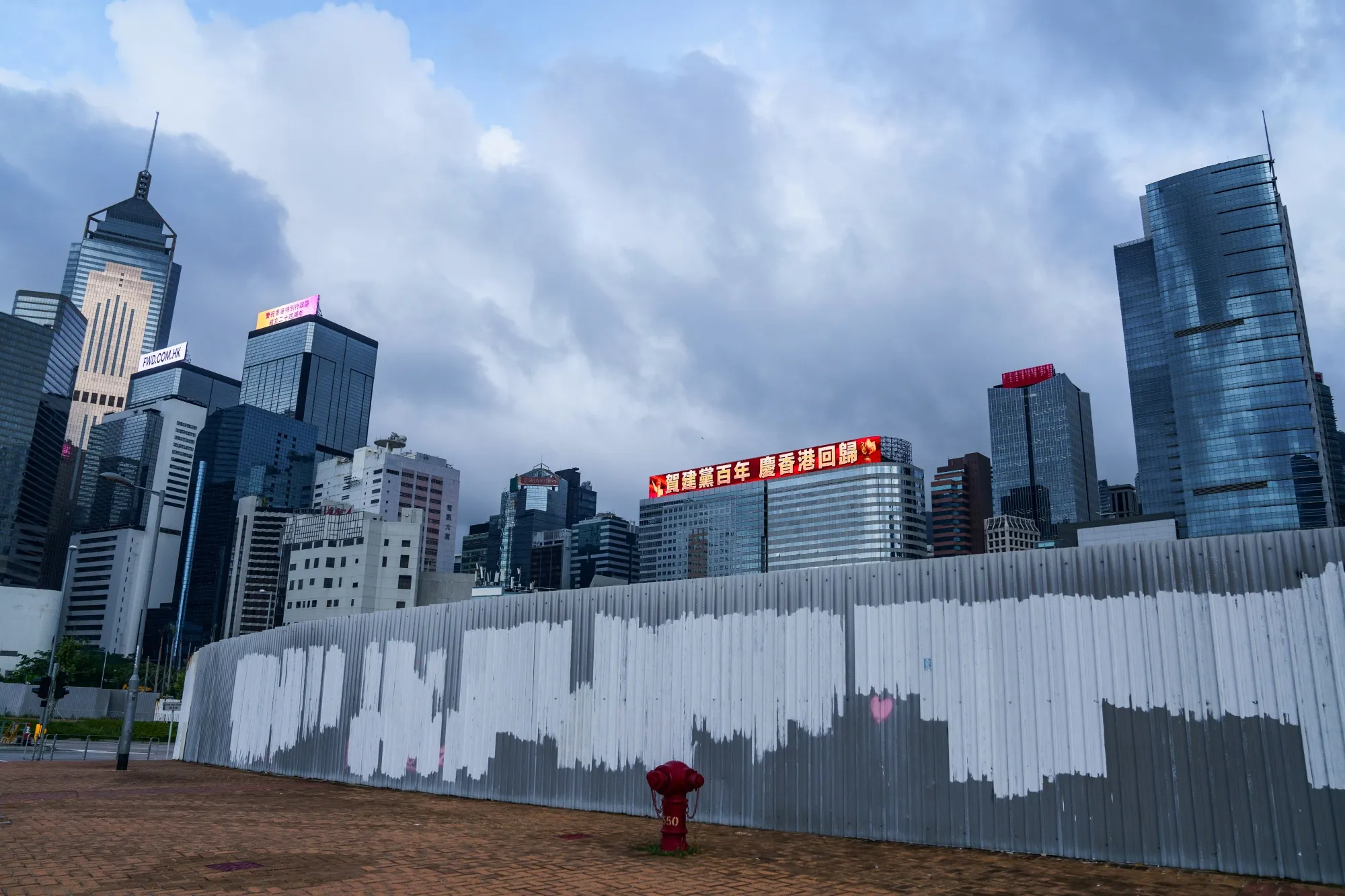 A banner displays a message marking the centenary of the Chinese Community Party and the anniversary of Hong Kong's return to Chinese rule atop the China Evergrande Center building in Hong Kong.